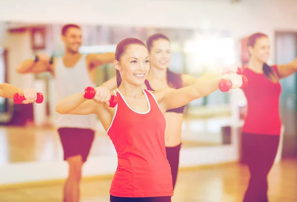 Grup gülümseyen insanların dumbell ile çalışma — Stok fotoğraf