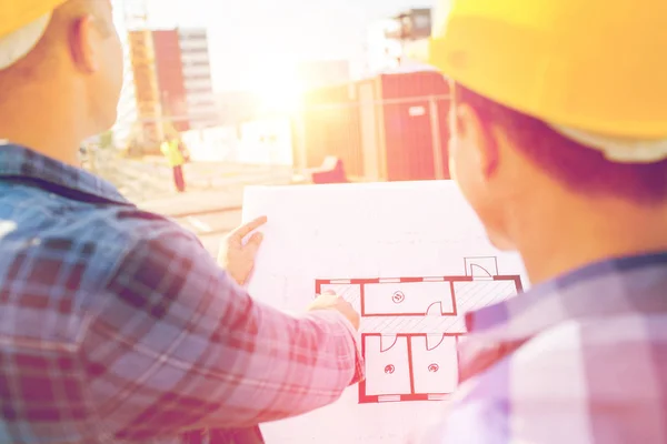 Nahaufnahme von Bauherren mit Bauplan am Bau — Stockfoto