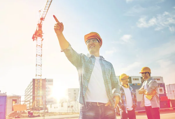 Constructores señalando el dedo a un lado en la construcción —  Fotos de Stock