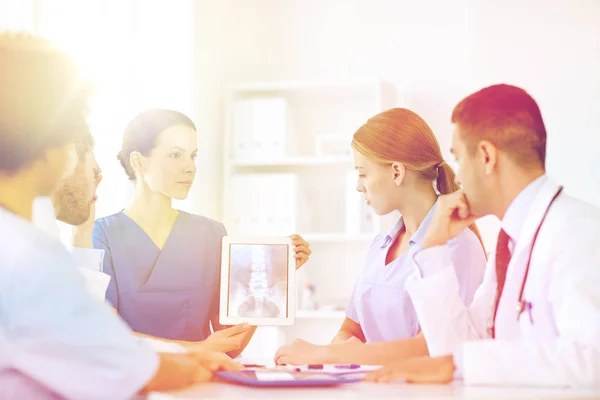 Arztgruppe mit Röntgenbild auf Tablet-PC in Klinik — Stockfoto