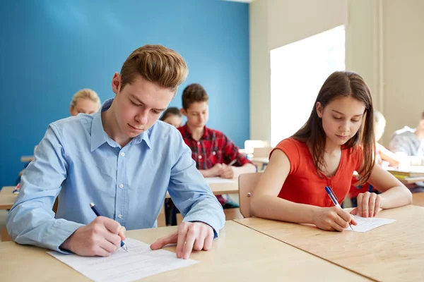 Gruppe von Schülern mit Büchern schreibt Schultest — Stockfoto