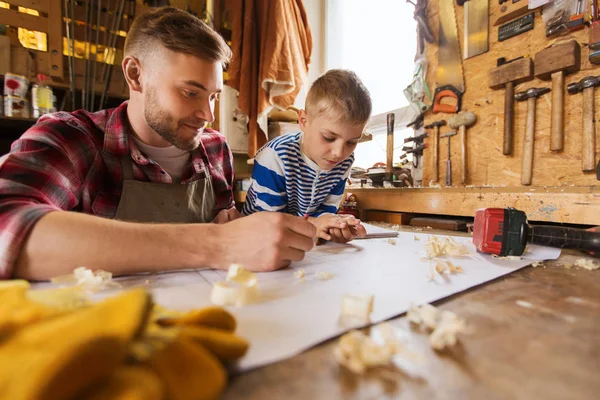 Lycklig far och son med blueprint på verkstad — Stockfoto