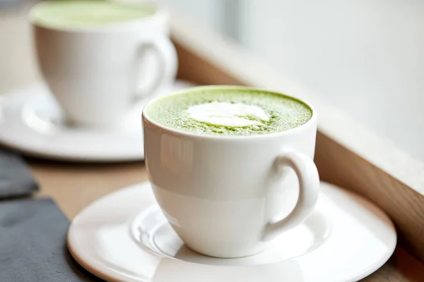 Bílý hrnek latte zelený čaj matcha na stole — Stock fotografie