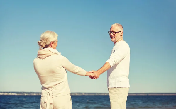 Щаслива старша пара тримає руки літній пляж — стокове фото