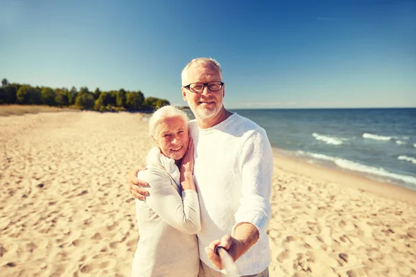 Senioren fotografieren mit Selfie-Stick am Strand — Stockfoto