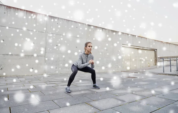 Žena dělá dřepy a cvičení venku — Stock fotografie