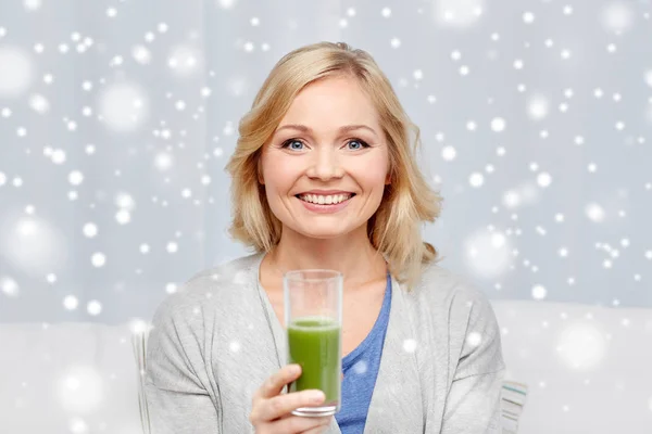 Donna felice bere succo verde o scuotere a casa — Foto Stock