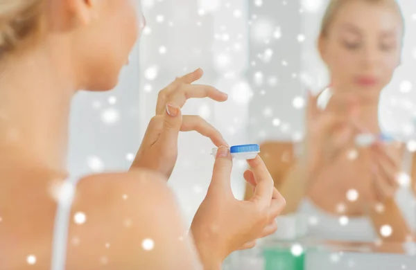 Mujer joven aplicando lentes de contacto en el baño — Foto de Stock