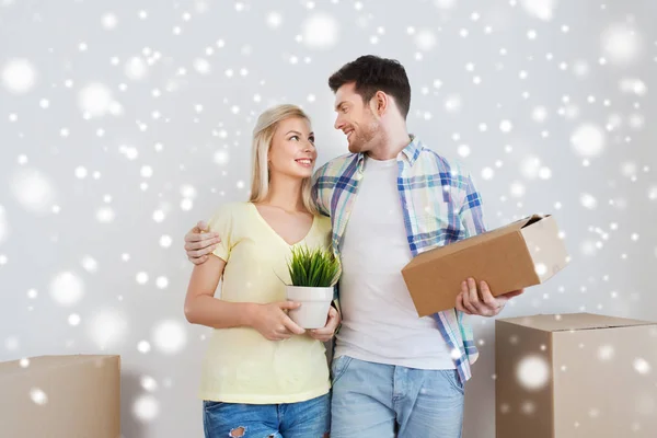 Smiling couple with boxes moving to new home — Stock Photo, Image