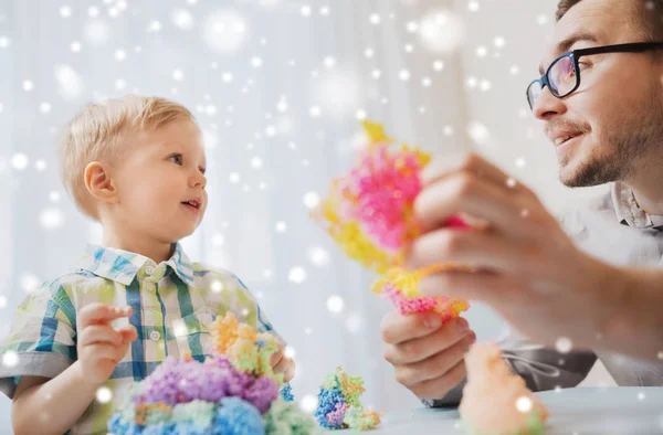 Far och son leker med bollen lera hemma — Stockfoto