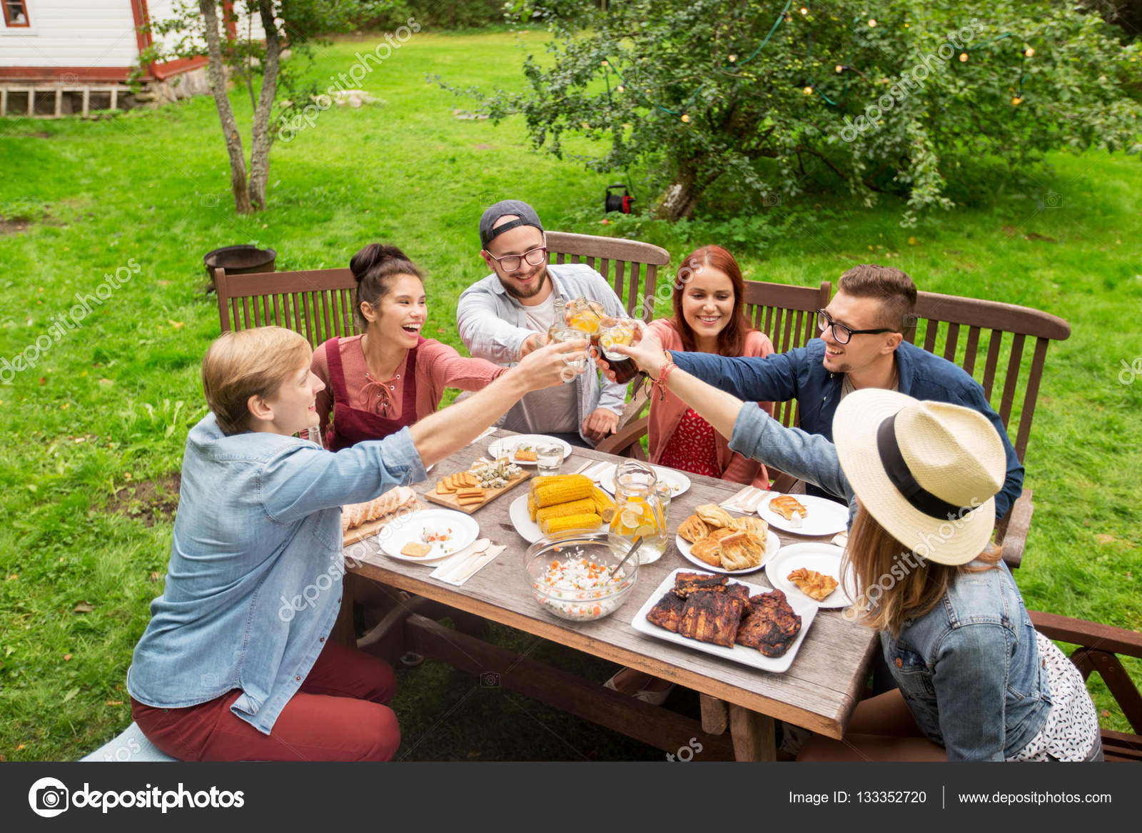 Glückliche Freunde beim Abendessen bei sommerlicher