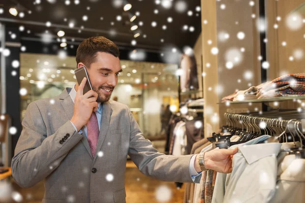 Šťastný muž volá na smartphone v obchodě s oděvy — Stock fotografie