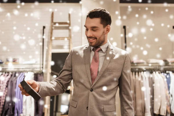 Happy man holding little box in clothing store — Stock Photo, Image
