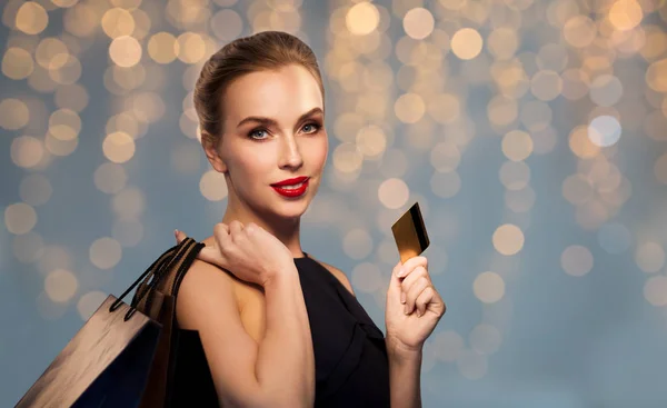 Mujer con tarjeta de crédito y bolsas de compras — Foto de Stock