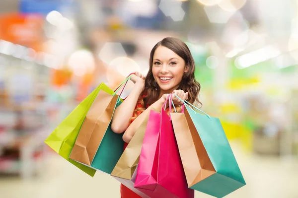 Kvinna med shoppingkassar i butik — Stockfoto