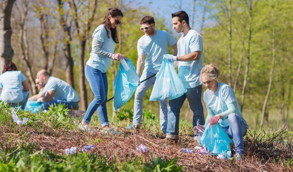 Volunteers with garbage bags cleaning park area — Stock Photo, Image