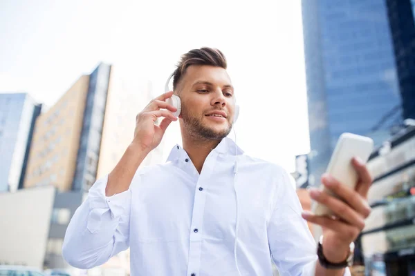 Hombre con auriculares y smartphone escuchando música — Foto de Stock