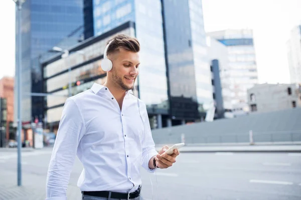 Mann mit Kopfhörer und Smartphone hört Musik — Stockfoto