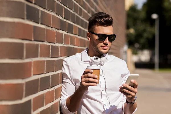 Man with smartphone and coffee cup on city street — Stock Photo, Image