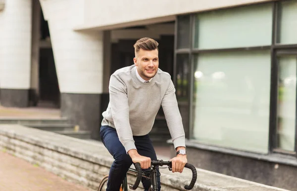 Joven montar en bicicleta en la calle de la ciudad — Foto de Stock