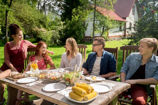 Glückliche Freunde beim Abendessen bei sommerlicher Gartenparty — Stockfoto