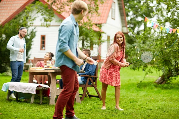 Amis heureux jouant au badminton au jardin d'été — Photo