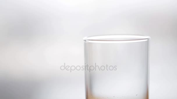 L'eau coulant dans le verre sur la table en bois — Video