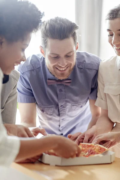 Equipe de negócios feliz comer pizza no escritório — Fotografia de Stock