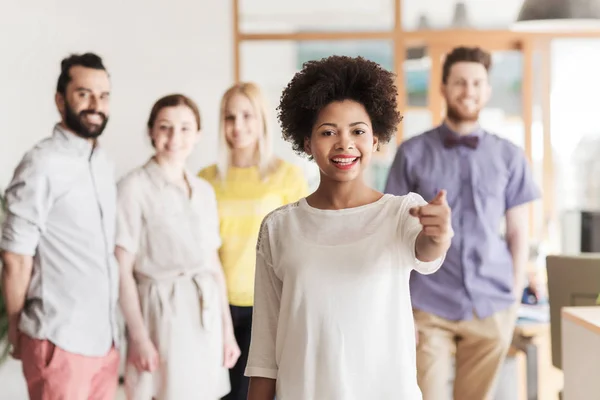 Mujer señalando a usted sobre equipo creativo de la oficina — Foto de Stock