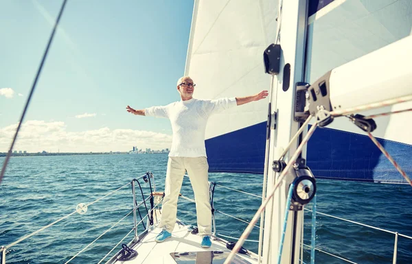 Homem sênior em barco à vela ou iate navegando no mar — Fotografia de Stock
