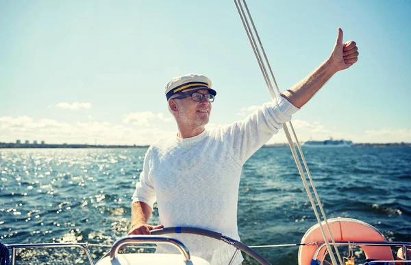 Homem sênior no leme em barco ou iate navegando no mar — Fotografia de Stock