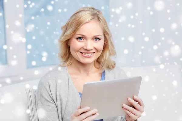 Счастливая женщина средних лет с планшетным компьютером дома — стоковое фото