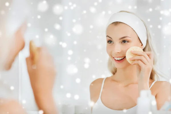 Wanita muda mencuci muka dengan spons di kamar mandi — Stok Foto