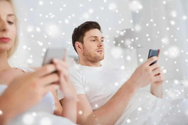 Pasangan dengan smartphone di tempat tidur — Stok Foto