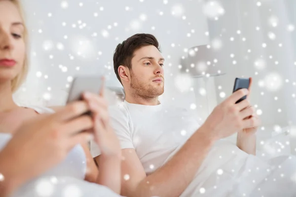 Coppia con smartphone a letto — Foto Stock