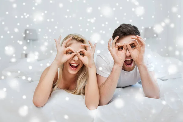 Happy couple lying in bed at home — Stock Photo, Image