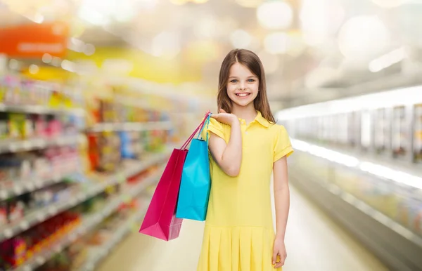小女孩微笑着在超市购物袋 — 图库照片
