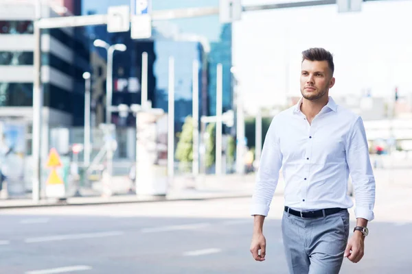 Jonge man wandelen langs stad straat — Stockfoto