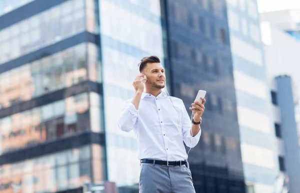 Hombre con auriculares y smartphone escuchando música — Foto de Stock