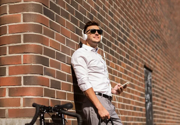 Hombre con auriculares, smartphone y bicicleta — Foto de Stock