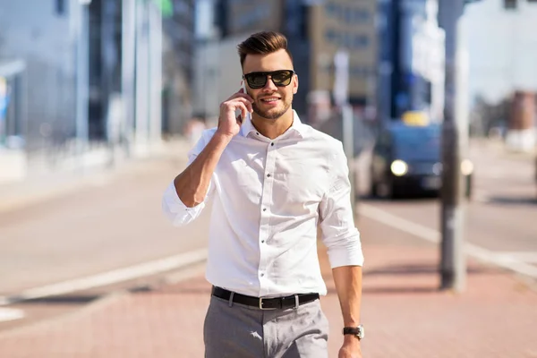 Happy man with smartphone calling on city street — Stock Photo, Image