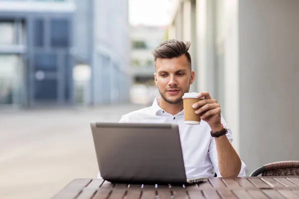 Man with laptop and coffee at city cafe — Stock Photo, Image