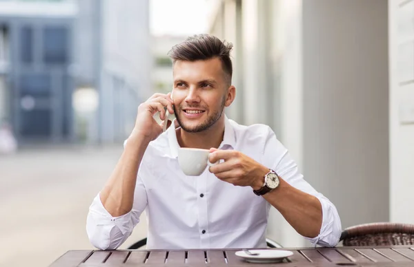 Hombre con café llamando en el teléfono inteligente en la cafetería de la ciudad —  Fotos de Stock