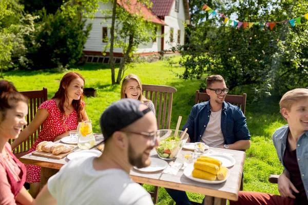 Glückliche Freunde beim Abendessen bei sommerlicher Gartenparty — Stockfoto