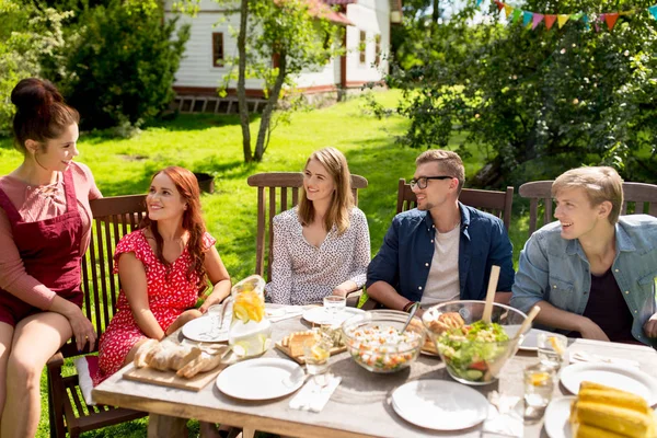 Amigos felizes jantando na festa do jardim de verão — Fotografia de Stock