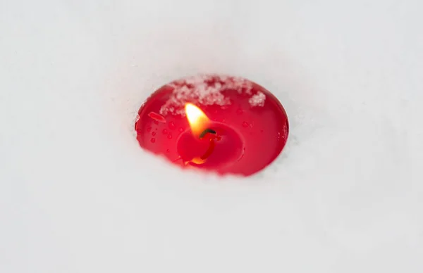 Сжигание рождественской свечи на снегу зимой — стоковое фото