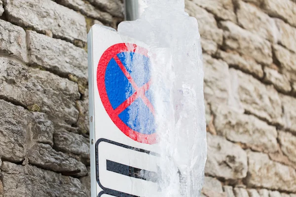 Ice-covered no stopping road sign over wall — Stock Photo, Image