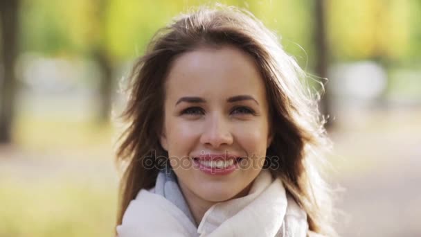 Hermosa mujer joven feliz sonriendo en el parque de otoño — Vídeos de Stock