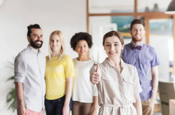 Femme montrant pouces vers le haut sur l'équipe de bureau créative — Photo