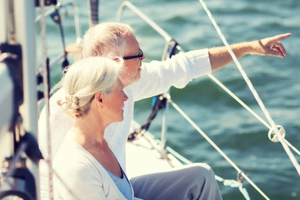 Счастливая старшая пара на парусной лодке или яхте в море — стоковое фото